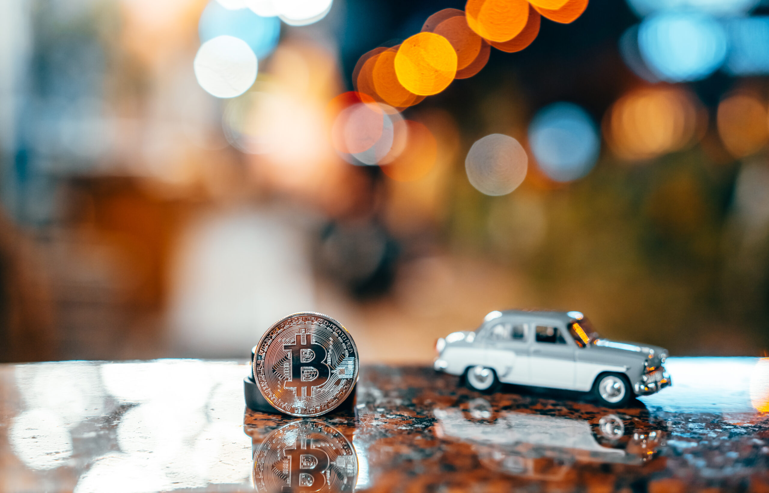 Silver bitcoin and Moskvich 401 on the table, glowing background